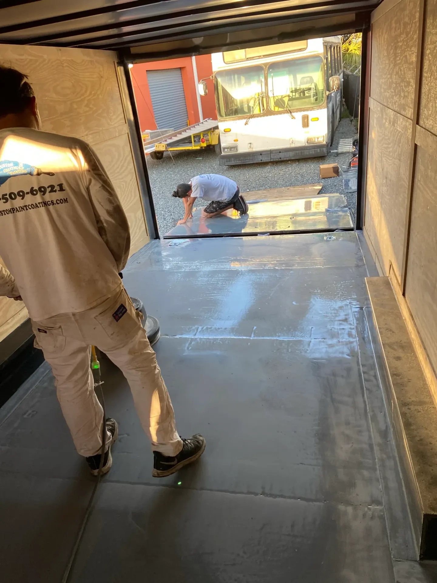 Coating work and reflective flooring inside an enclosed trailer.