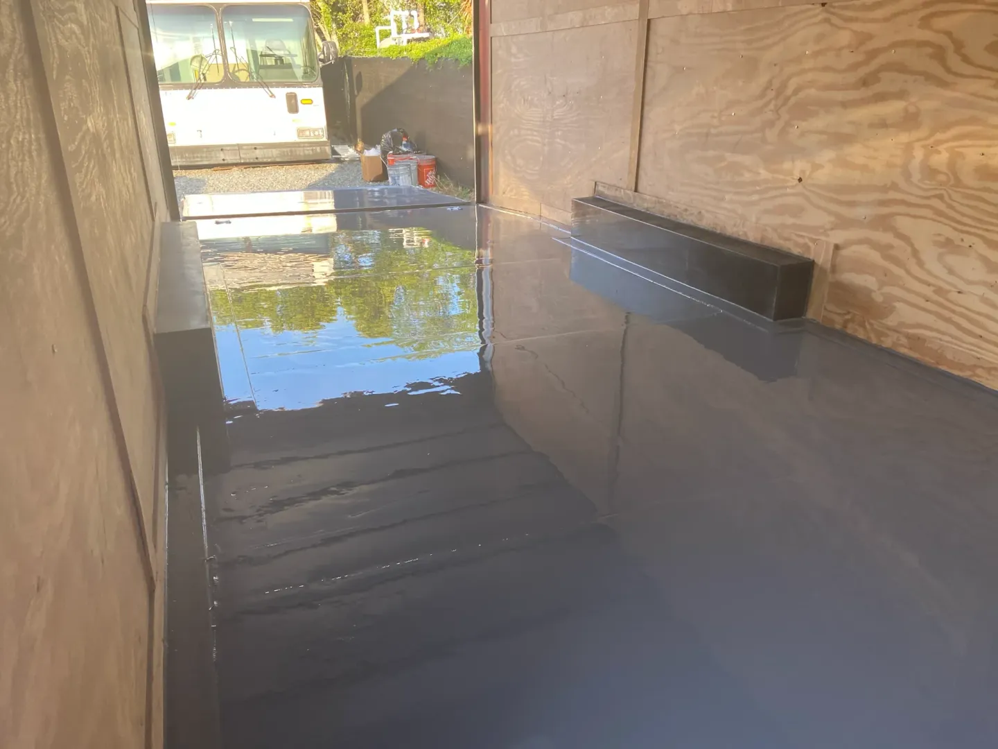 Coating work and reflective flooring inside an enclosed trailer.