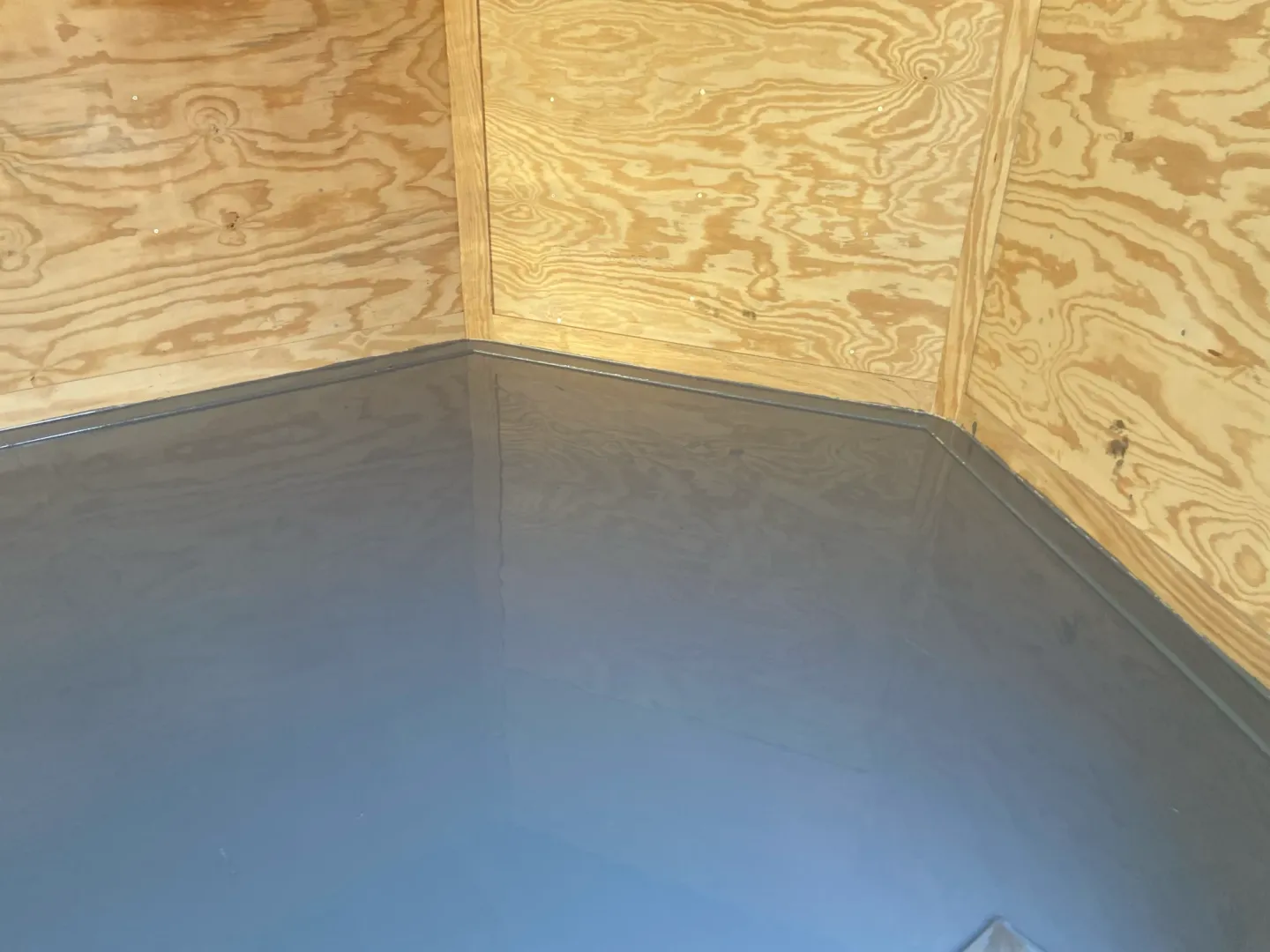 Coating work and reflective flooring inside an enclosed trailer.