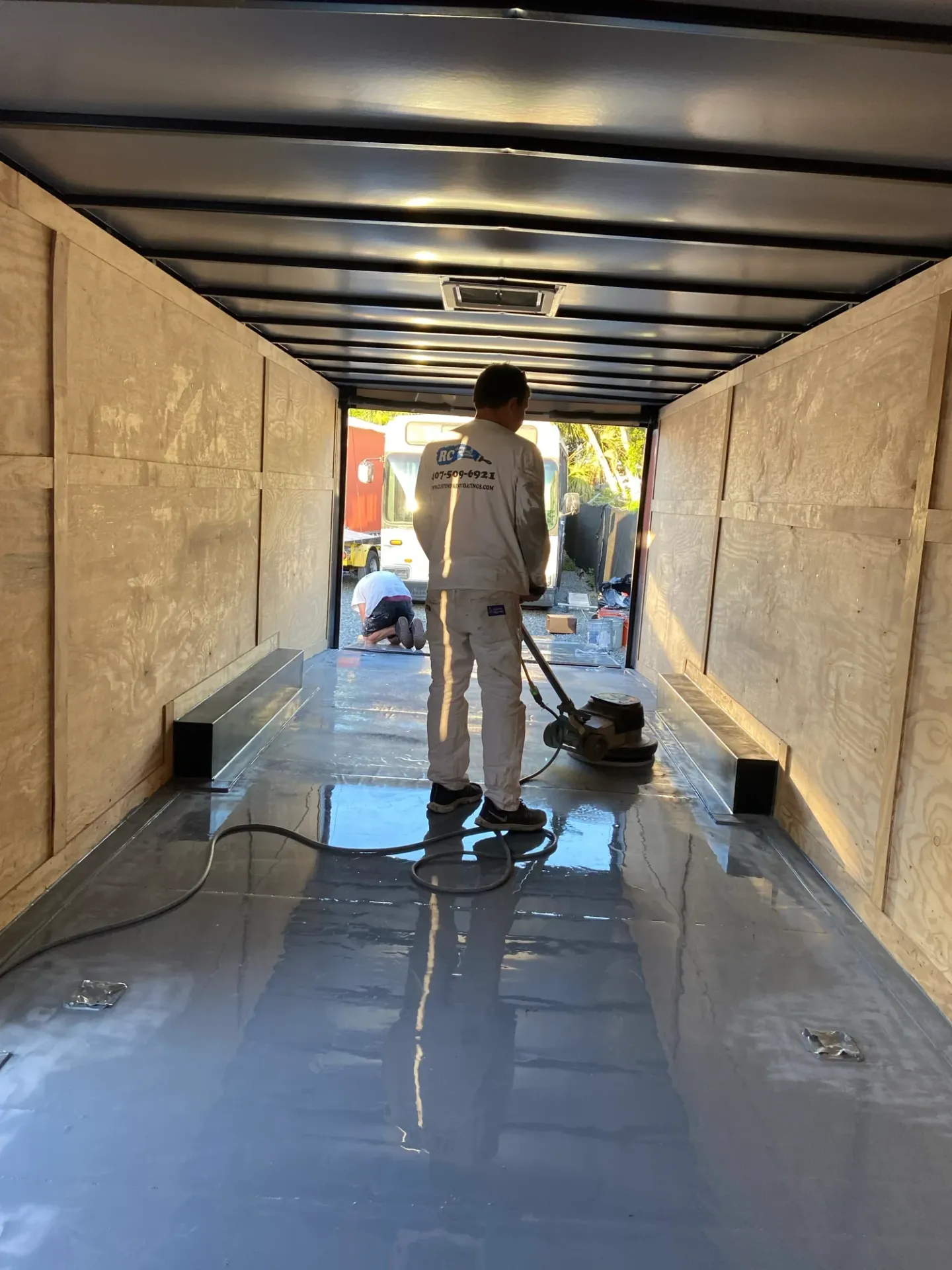 Coating work and reflective flooring inside an enclosed trailer.