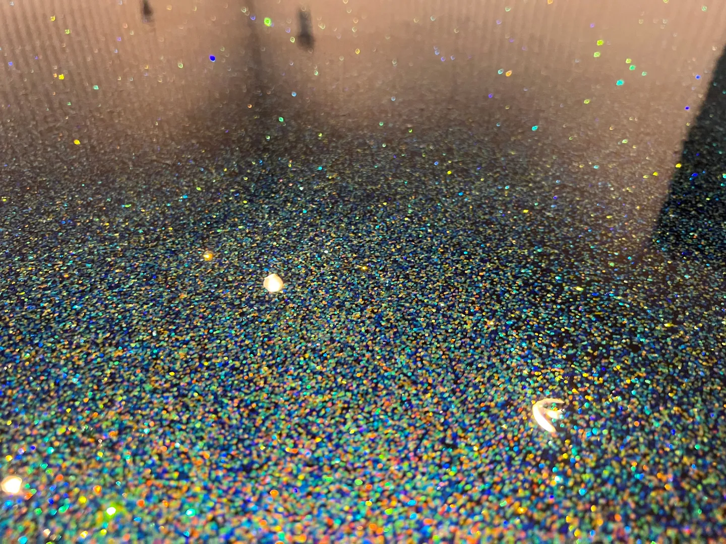 Reflective floor with multicolor speckled detail.