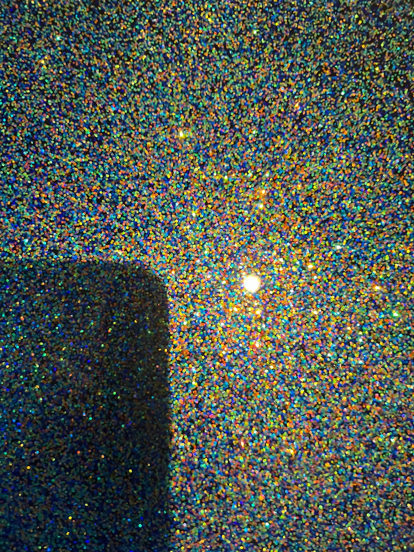 Reflective floor with multicolor speckled detail.