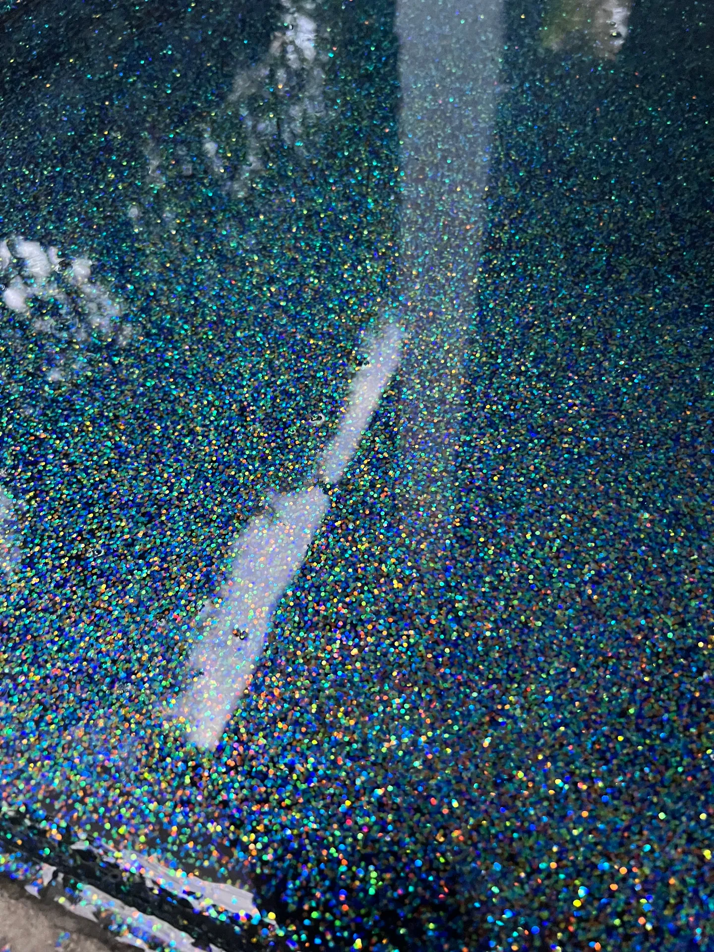 Reflective floor with multicolor speckled detail.