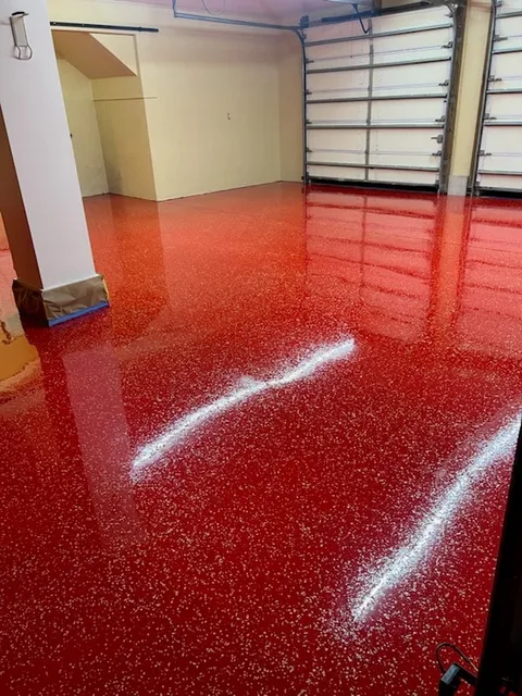 Reflective red speckled floor in a garage or work interior.