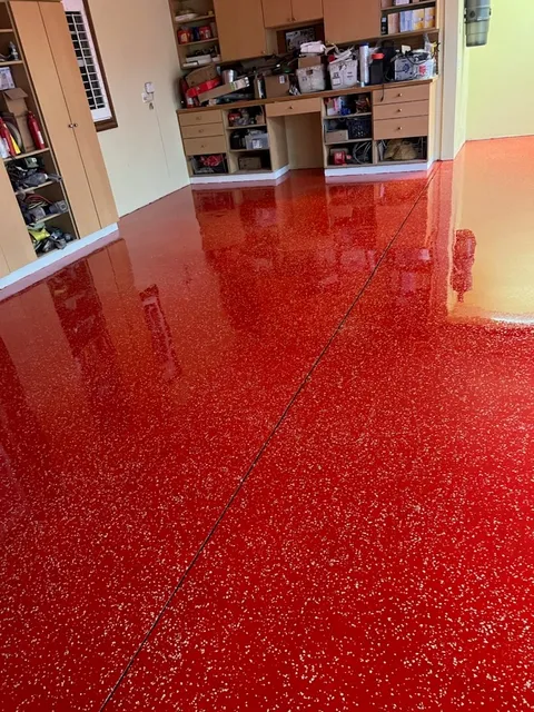 Reflective red speckled floor in a garage or work interior.